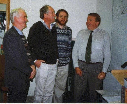 four dudes at the white board sharing a joke